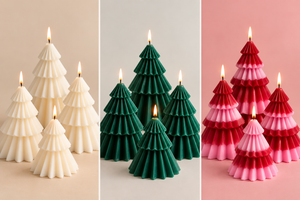 Three sets of Christmas tree-shaped candles lit and arranged side by side on neutral pastel backgrounds. The left set is cream, the center set is dark green, and the right set is red and pink ombre.